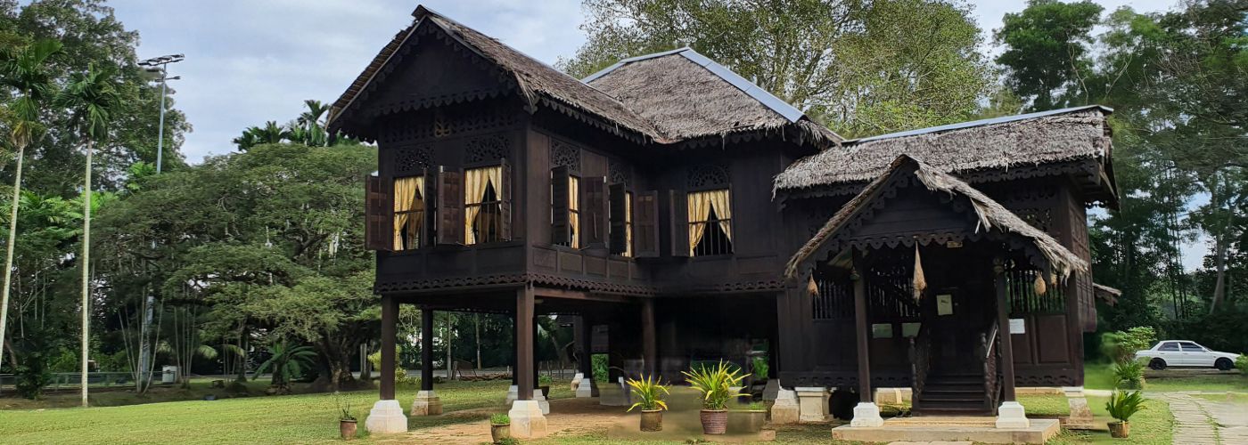 Traditional Malay wooden bungalow in a large compound representing a court-ordered sale of trust property